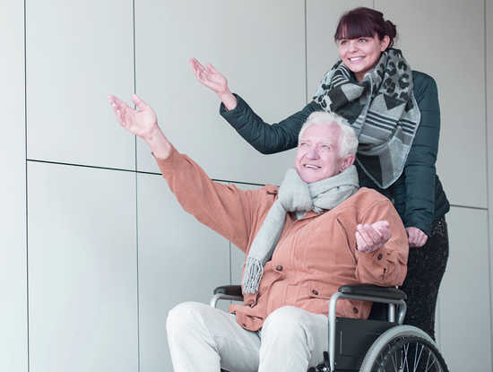 badante e anziano non autonomo in passeggiata nei dintorni di biella